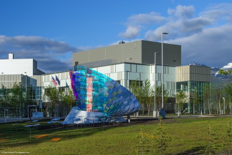 Large multistory building with decorative panelling and large sculpture in front yard