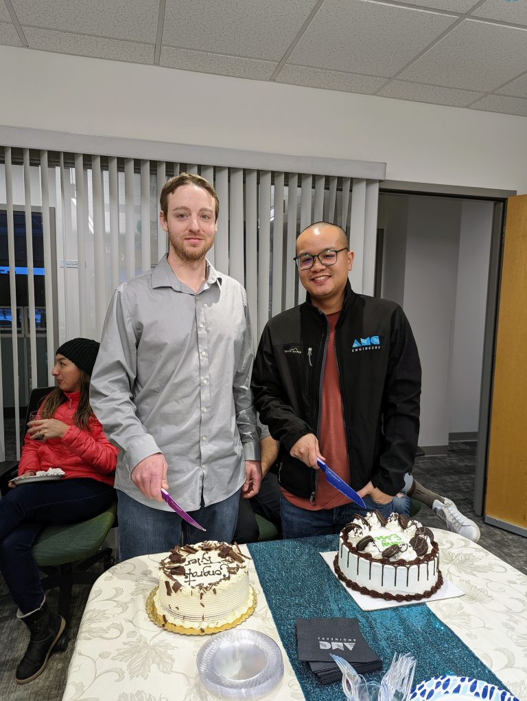 Tyler standing in front of a cake that says Congrats Tyler