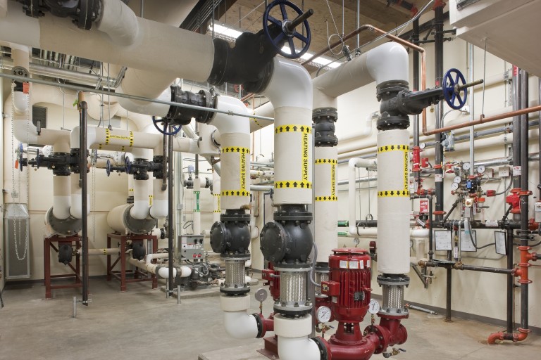 Large machinery and pipes filling walls and ceiling of room