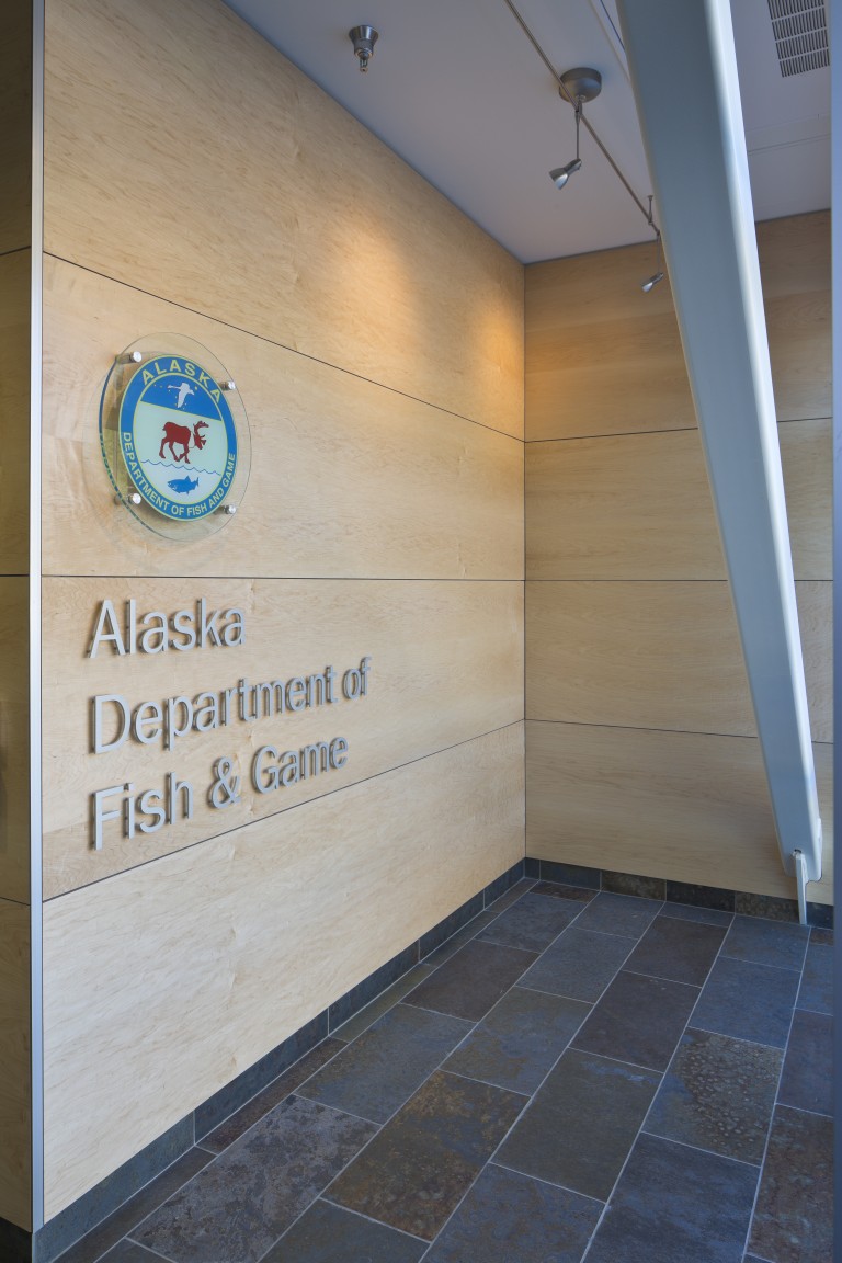Wood paneled wall with placard for Alaska department of Fish and Game