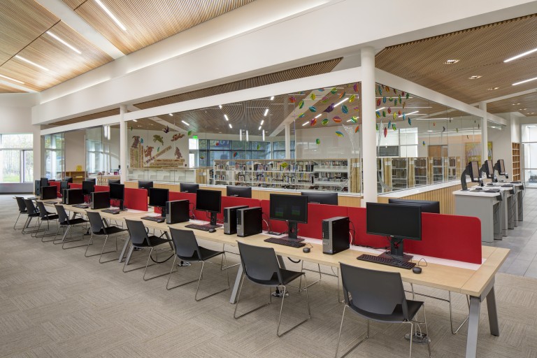 Brightly lit library with wood grated ceilings
