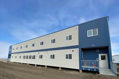 White and blue elevated building with metal grate walls